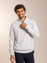 Sweater de punto en color gris claro, con cuello alto y medio cierre frontal. Presenta puños y ruedo acanalados para un ajuste cómodo.