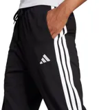 Pantalón de jogging Adidas Essentials Jogger W, color negro, con cintura ajustable con cordón y puños elásticos en los tobillos. Presenta el logo de Adidas en blanco en la pierna izquierda.