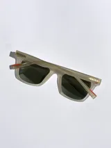 Lentes de sol con armazón bicolor, frente negro y patillas en tono beige con detalle de marca grabado. Cuentan con cristales polarizados con protección UV 400.
