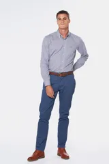 Pantalón de gabardina color marrón claro, corte slim fit, con bolsillos laterales y traseros. Se ajusta a la cintura con cinturón de cuero marrón.