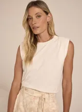 Musculosa blanca de tejido de punto, con corte holgado, cuello redondo y sisas amplias.