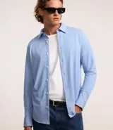 Camisa de manga larga blanca, corte slim fit, con cuello tradicional y abotonadura frontal.