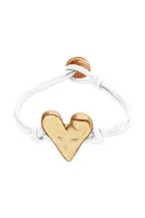 Pulsera ajustable con cordón blanco y dije central de corazón martillado con baño dorado. Incluye una cuenta redonda marrón como tope ajustable.