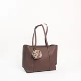 Cartera tipo tote de cuero sintético en color marrón, con textura granulada, doble asa de hombro y un pequeño monedero circular colgante con estampado animal print.