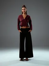 Top corto color bordó, con escote en V, mangas largas abullonadas con puños elásticos y fruncido en la parte delantera.