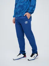 Pantalón de entrenamiento Umbro del Club Nacional de Football, modelo Grok en color azul. Presenta el escudo del club en una pierna y el logo de Umbro en la otra, con diseño cómodo y deportivo.