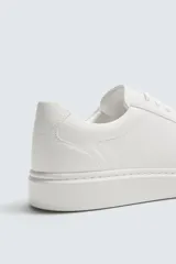 Zapatilla urbana monocolor de diseño minimalista con cordones al tono, puntera redondeada y suela con volumen.