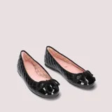 Bailarinas negras de cuero capitoneado con puntera de charol y moño decorativo. Interior de cuero color rosa y suela de goma antideslizante.