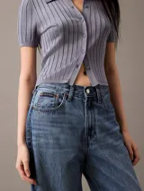 Pantalón de jean corte relaxed de pierna ancha, con diseño clásico de cinco bolsillos, cierre de botón y cremallera, en un lavado azul medio.