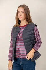 Chaleco acolchado de nylon color negro, con cierre frontal de botones a presión y cuello redondo.