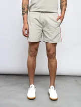 Short de baño negro con una banda vertical blanca en el lateral con el logo de Umbro en color rosa.