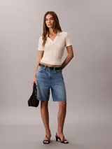 Shorts tipo bermuda de corte relajado y talle alto, confeccionados en una mezcla de algodón y lino. Presentan un diseño clásico de cinco bolsillos, cierre con cremallera y botón, y pespuntes decorativos.