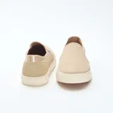 Zapatillas bajas sin cordones color beige de malla con suela blanca.