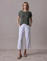 Pantalón blanco de lino y rayón, corte ancho (wide leg) y largo crop (por encima del tobillo). Presenta pretina trasera elastizada y bolsillos delanteros.