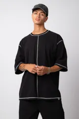 Remera manga corta color lila con costuras blancas a la vista.