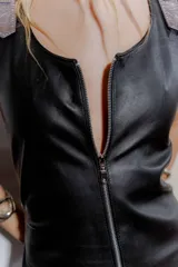 Vestido largo negro de cuero ovino con cierre frontal de cremallera metálica, sin mangas y con tajo lateral.