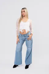 Pantalón wide leg de tiro medio-bajo, con corte holgado y pernera ancha. Presenta un diseño clásico de cinco bolsillos con cierre de botón y cremallera, en un tono azul claro con acabado lavado.