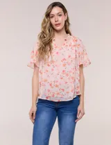 Blusa blanca de doble capa de gasa con estampado floral en tonos amarillos, celestes y rosados, escote en V con frunces y mangas cortas con volados amplios.