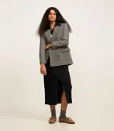 Blazer de tweed gris con diseño de espiga, doble botonadura, solapas de muesca, bolsillos cargo frontales y corte clásico.