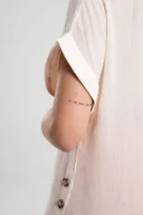 Blusa color blanco de corte holgado, con mangas cortas y detalle de botones en el lateral.