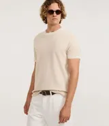 Remera de corte regular confeccionada en tejido de algodón texturizado, con cuello redondo y detalles de rayas contrastantes en el borde del cuello y las mangas.