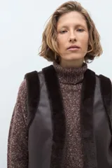 Chaleco reversible de corte recto, con un lado de cuero sintético color chocolate y el otro lado de piel sintética al tono. Presenta cuello redondo y diseño sin mangas.