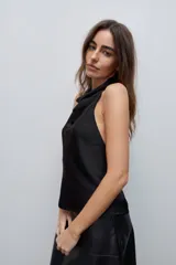 Top negro de cuello drapeado con espalda descubierta y calce fluido.