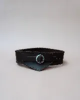 Faja de cuero negro con diseño ancho y costuras decorativas en los bordes. Presenta una hebilla metálica circular plateada en el centro y un diseño asimétrico en la parte frontal.