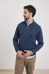 Sweater verde oliva de tejido acrílico con textura similar al cashmere, corte clásico, cuello alto con cierre metálico y tirador de cuerina ecológica.