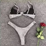 Conjunto de bikini plateado brillante, con corpiño con aros y bombacha tipo tanga.