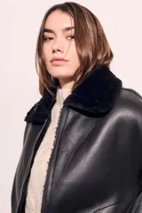 Campera gamulan negra con cuello, puños y ruedo de piel sintética.