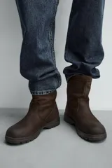 Bota de cuero con acabado abatanado, horma redonda y suela track con volumen. Cuenta con plantilla interior de cuero y tirador en la parte trasera.