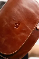 Cartera bandolera marrón de cuero natural con estructura rígida, forro interior de tela, bolsillo interno con cierre y terminaciones impecables.