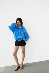 Shorts mini de tiro bajo en color negro, con bolsillos de plastrón en el delantero y cierre lateral con cremallera oculta.
