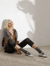 Zapato plano estilo Mary Jane de cuero negro, con punta fina y tira ajustable con hebilla sobre el empeine.