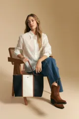 Camisa blanca de manga larga con textura calada o bordada, cuello camisero y corte holgado.