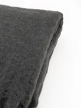Bufanda de tejido suave y esponjoso en color gris, con diseño de flecos en los extremos.