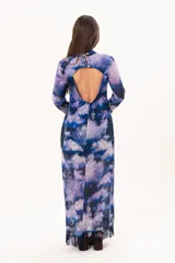 Vestido largo de manga larga con terminación campana, de color azul y violeta con estampado tie-dye, cuello mao con ojal y tajo frontal. Cuenta con flecos en el ruedo y tajo en la pierna.