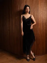 Top de terciopelo negro con breteles finos y detalle de encaje en el escote.