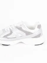 Zapatillas deportivas de estilo urbano, color blanco con detalles en plateado, confeccionadas en malla y material sintético, con suela de goma.