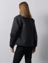 Campera beige capitoneada con capucha, cierre frontal y bolsillos laterales.