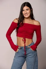 Top de algodón color marrón, con escote off-shoulder, mangas largas y detalle de frunce central con lazo ajustable.