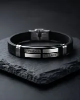 Pulsera de diseño masculino fabricada en acero inoxidable y goma negra, con detalles metálicos decorados con un patrón de guarda griega.