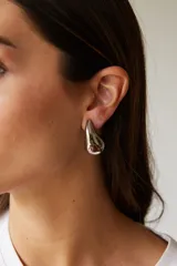 Aros colgantes dorados con forma de gota.