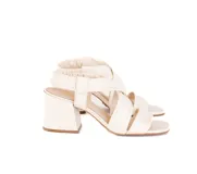 Sandalias de tacón medio color blanco hueso, con tiras cruzadas acolchadas en la parte delantera y talonera elástica fruncida. Tienen punta cuadrada y tacón ancho de 6 cm.