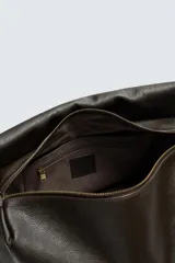Bolso tipo bandolera de gran tamaño fabricado en piel con acabado grabado. Cuenta con un compartimento principal con cierre de solapa magnética y cremallera, además de bolsillos interiores. Incluye un asa de hombro ajustable en piel.
