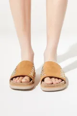 Sandalias bajas color marrón, con base de corcho y tira ancha de gamuza con pespuntes decorativos en hilo dorado.