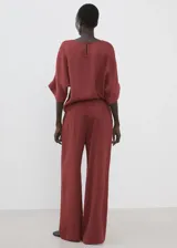 Pantalón palazzo largo de tiro alto, color bordó, con cintura elástica y lazo ajustable.