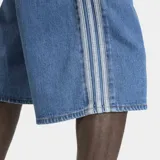 Short de jean estilo bermuda de corte holgado, color azul medio. Presenta las icónicas tres rayas laterales de Adidas en tono más claro y cierre de botón frontal. Incluye bolsillos delanteros y traseros.