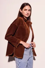 Sobrecamisa de pana color rojo, con cierre frontal de botones, bolsillos delanteros con solapa y ruedo desflecado.